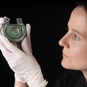 Conservator Bethan Bryan holds a bronze fitting